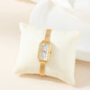 Theresa – Reloj dorado con esfera rectangular.