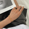 Lena – Pulsera dorada con delicada estructura de cordón