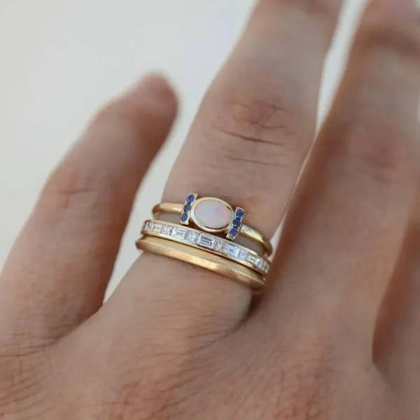 Theresa – Un fino anillo de oro con un opal brillante y contornos claros.