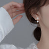 Klara – Pendientes circulares dorados con perlas.