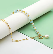 Zoé – Pendientes largos dorados con colgante de perla.