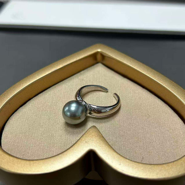 Ida – Golden ring with a smooth surface and pearl accent.