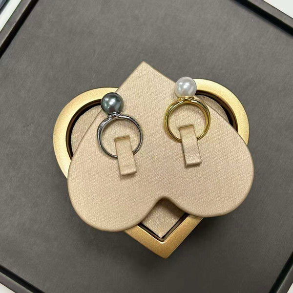 Ida – Golden ring with a smooth surface and pearl accent.
