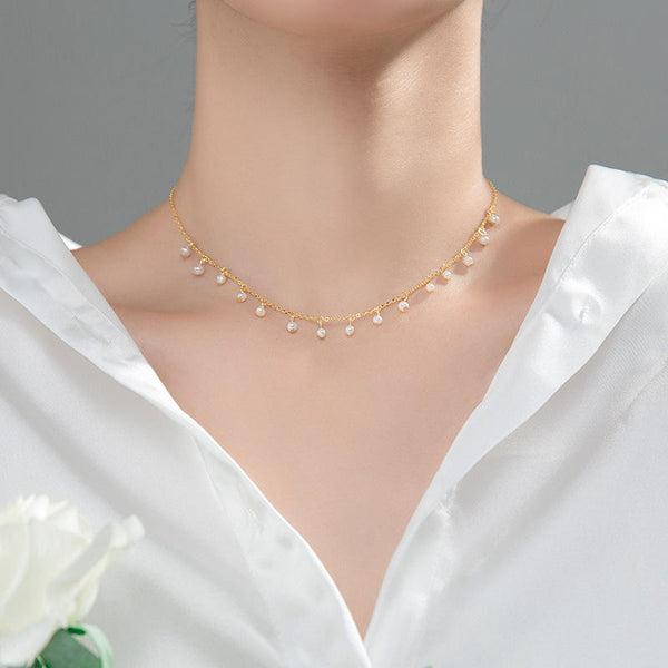 Irma – Pendientes de perlas redondas con borde dorado texturizado.