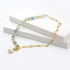 Zoé – Pendientes largos dorados con colgante de perla.