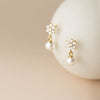 Klara – Pendientes circulares dorados con perlas.