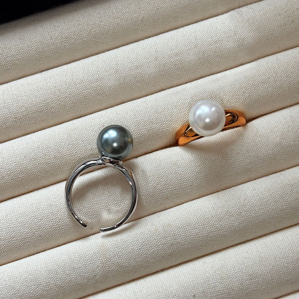 Ida – Golden ring with a smooth surface and pearl accent.