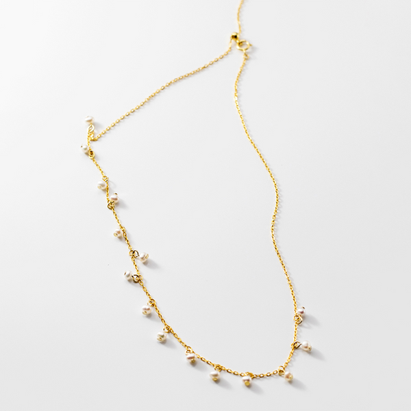 Irma – Pendientes de perlas redondas con borde dorado texturizado.