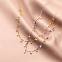 Irma – Pendientes de perlas redondas con borde dorado texturizado.