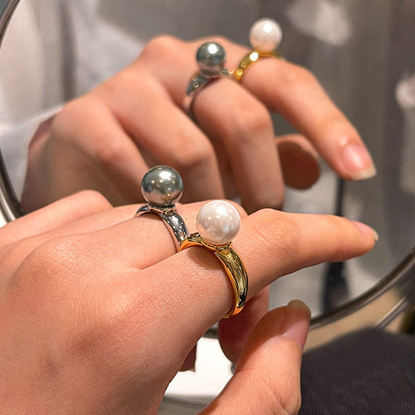 Ida – Golden ring with a smooth surface and pearl accent.