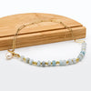 Zoé – Pendientes largos dorados con colgante de perla.