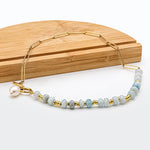Zoé – Pendientes largos dorados con colgante de perla.