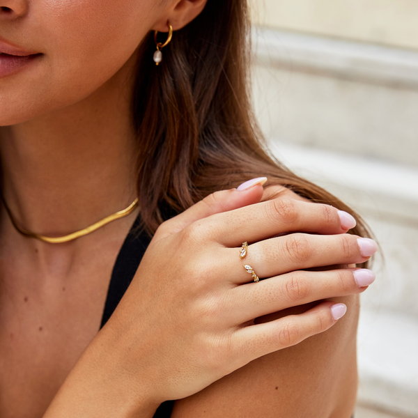Johana – Anillo dorado con forma abierta y curvada.