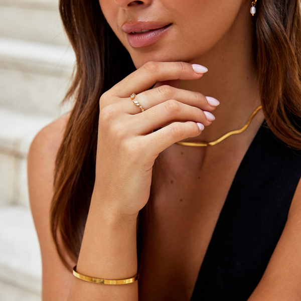 Johana – Anillo dorado con forma abierta y curvada.