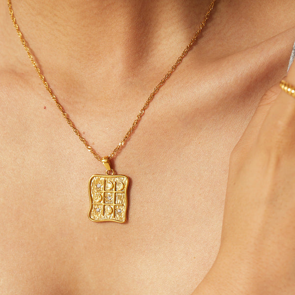 Alžběta – Collar dorado con pequeños colgantes simbólicos.