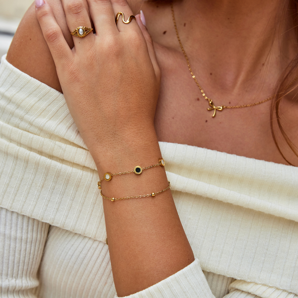Carla – Pulsera dorada suave con elementos redondos contrastantes.