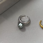 Ida – Golden ring with a smooth surface and pearl accent.