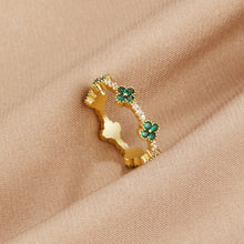 Annika – Gold ring with floral details and an emerald element.