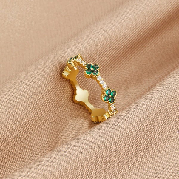 Annika – Anillo dorado con detalles florales y elemento de esmeralda.