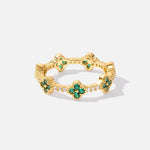 Annika – Anillo dorado con detalles florales y elemento de esmeralda.