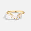 Johana – Anillo dorado con forma abierta y curvada.