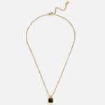 Selina – Collar dorado con piedra oscura.