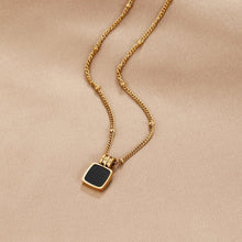 Selina – Gold necklace with dark stone.
