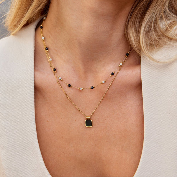 Theresa – Collar delicado con sutiles detalles en blanco y negro.