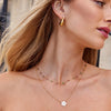 Alena – Collar dorado con colgante de flor.